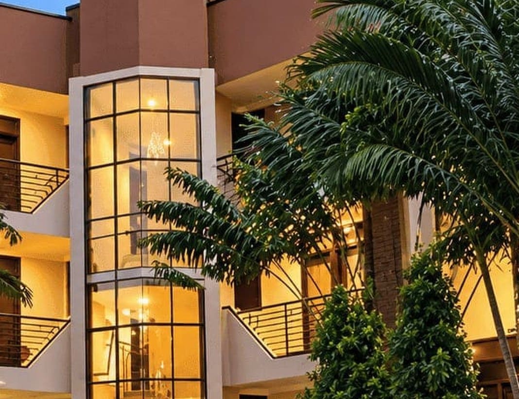 The glass lift tower and palm garden at Nakawa Hotel & Suites